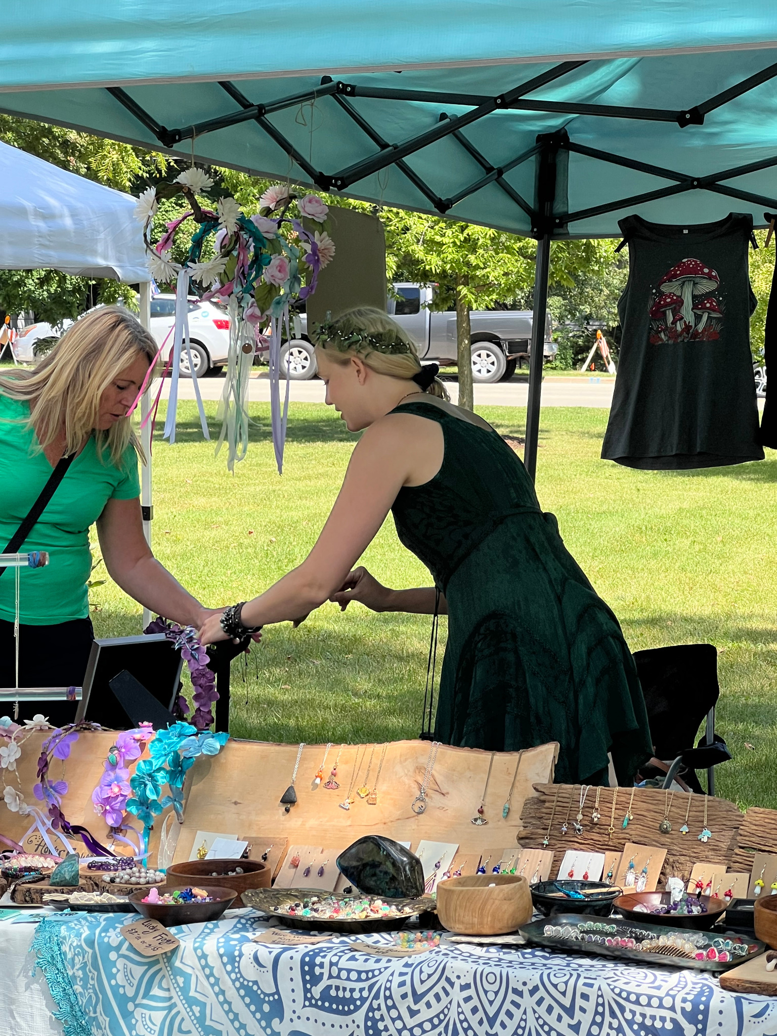 Artist Kelsey Rankin standing behind her Hemp Club Jewelry display at a Fox Valley market.
