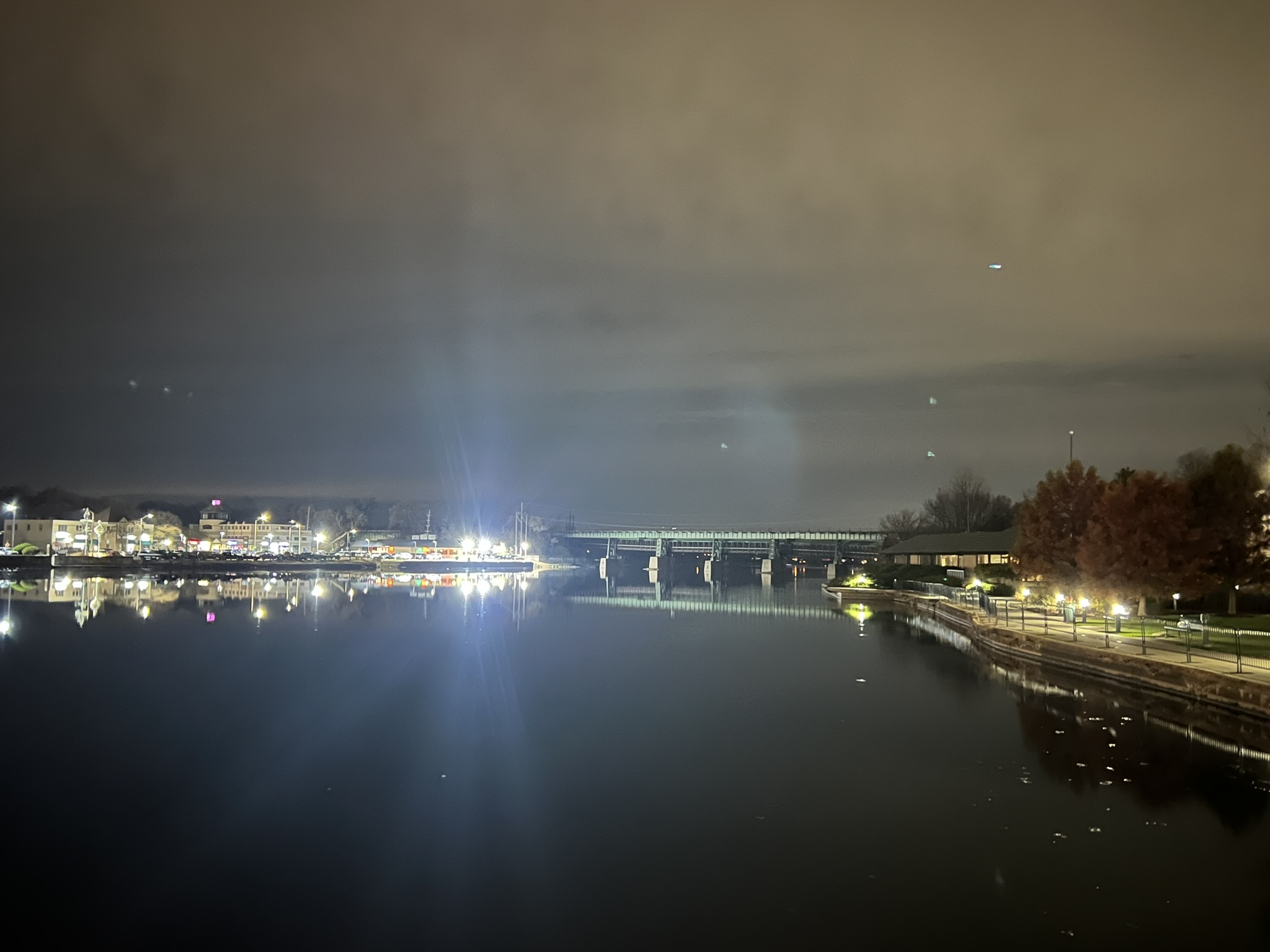 Twilight view of the St. Charles riverwalk with lights reflecting on the Fox River